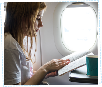 Woman reading a book whilst travelling on an aeroplane