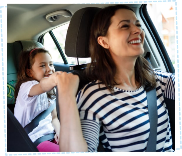 Mother and young daughter enjoying a car journey together