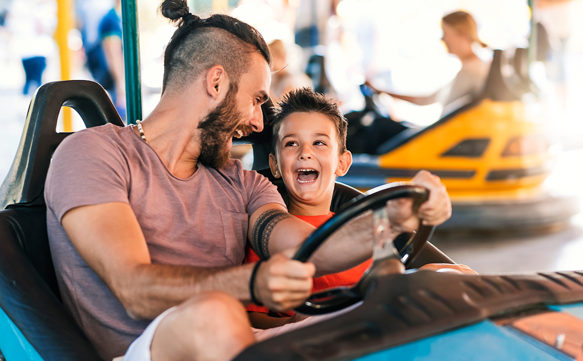 Father and son enjoying the dodgems at a fairground