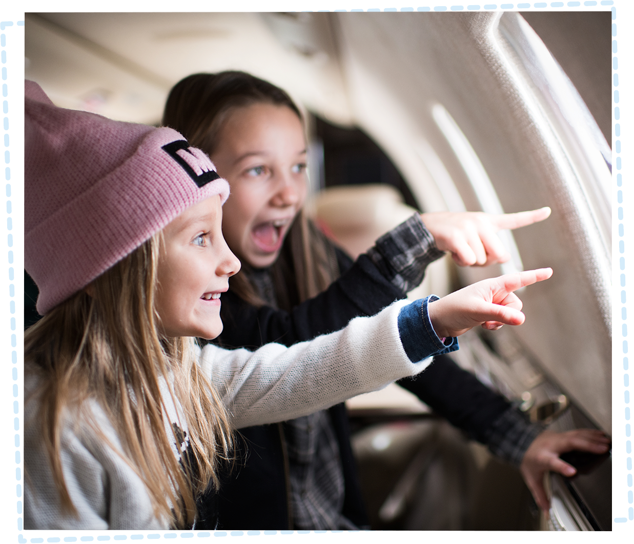 Two little girls looking out of the window on an aeroplane