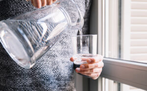 Woman pouring a glass of water from a jug