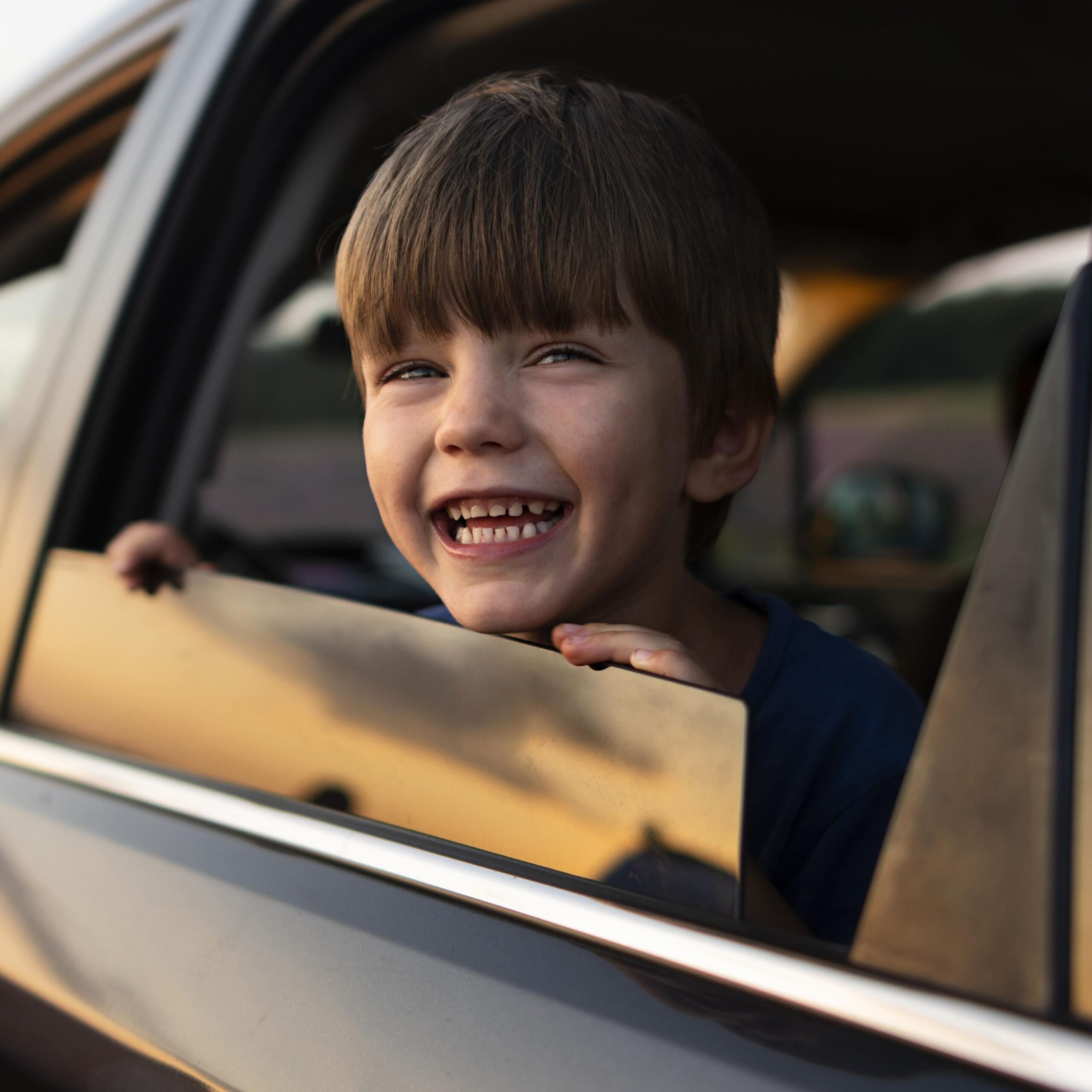 Smiley child looking out of a car window