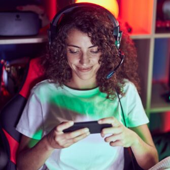 young hispanic woman streamer playing video game using smartphone gaming room e1753275946420