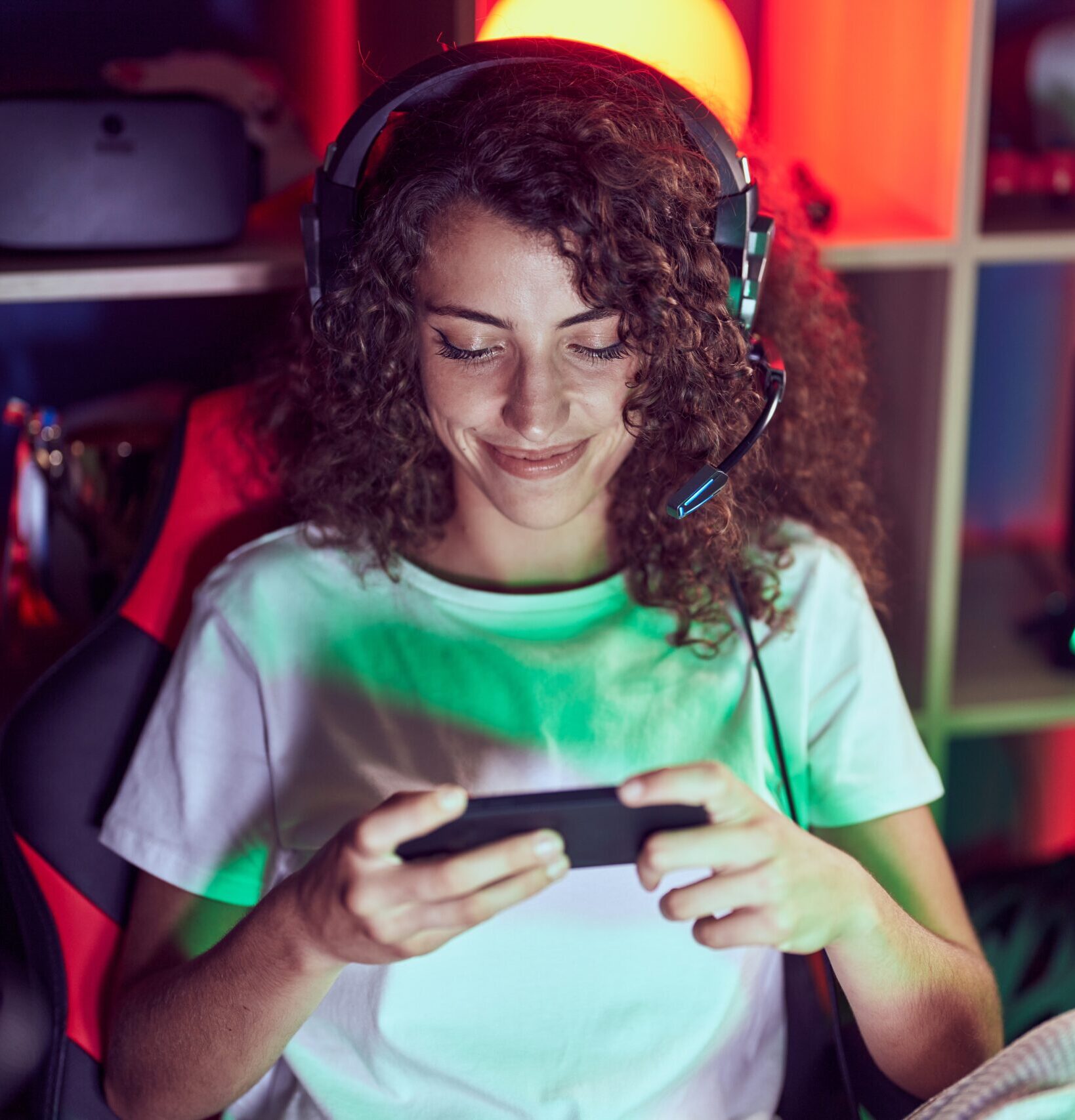 young hispanic woman streamer playing video game using smartphone gaming room e1753275946420